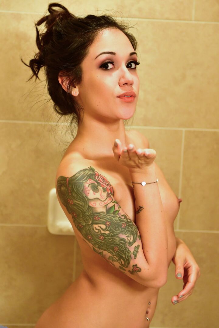 16P La joven tatuada Jynx Correra se recoge el pelo antes de desnudarse para ducharse
