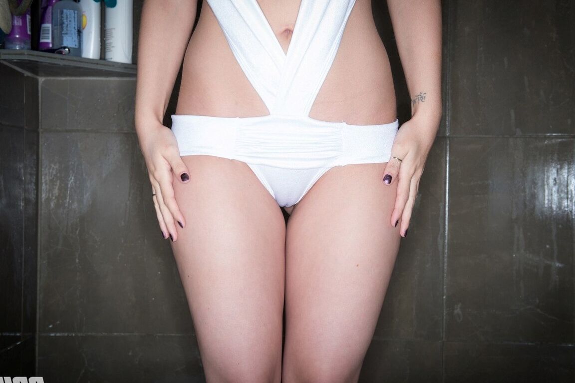 Das 15P-Amateurmodel Bryci zieht ihre Badebekleidung aus, um nackt in einer Duschkabine zu posieren