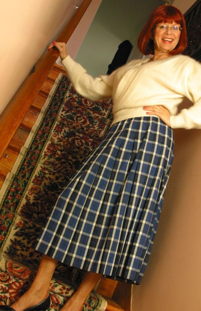 12P Miss Abigail, rousse et plus âgée, expose sa culotte en jupe haute avant de déboutonner ses seins.