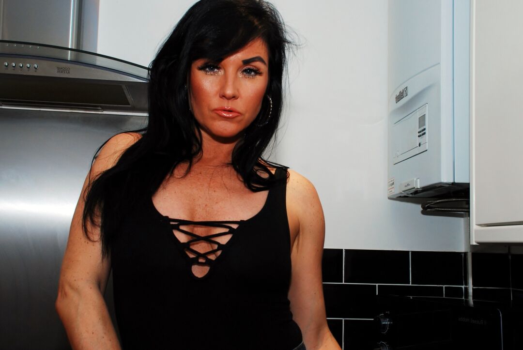 20P Amateur model Raunchy Raven removes a denim miniskirt while in her kitchen