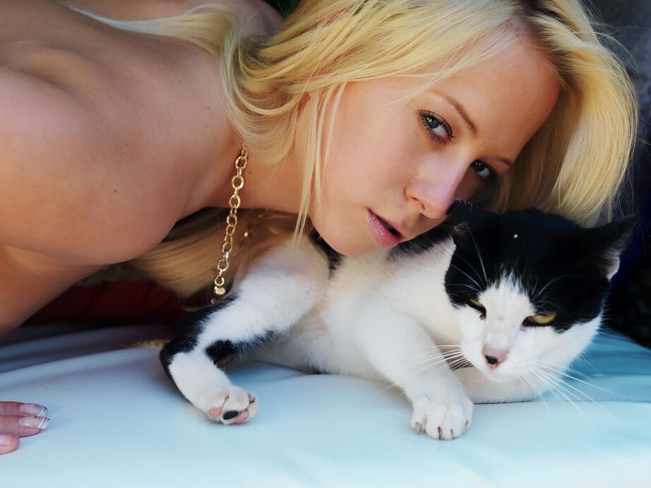 16P A loira sexy Zana atrai um gato enquanto modela nua em móveis de jardim