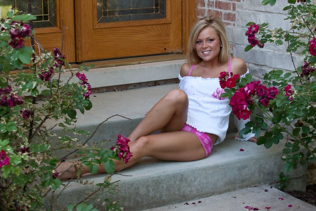 15P Blonde female Meet Madden smells the roses while undressing on front steps