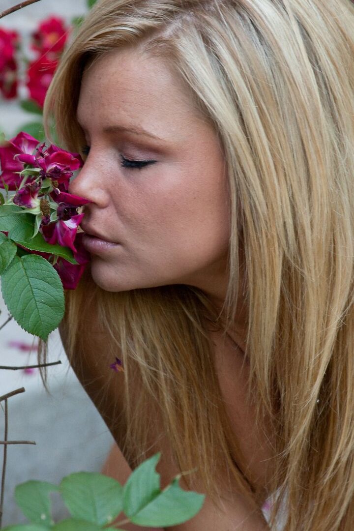 15P Blonde female Meet Madden smells the roses while undressing on front steps