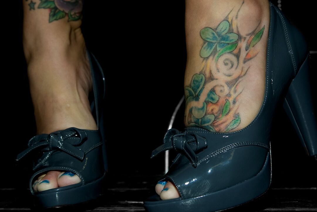 11P La séduisante MILF Claire Dames affiche son décolleté et ses pieds encrés entièrement habillés.