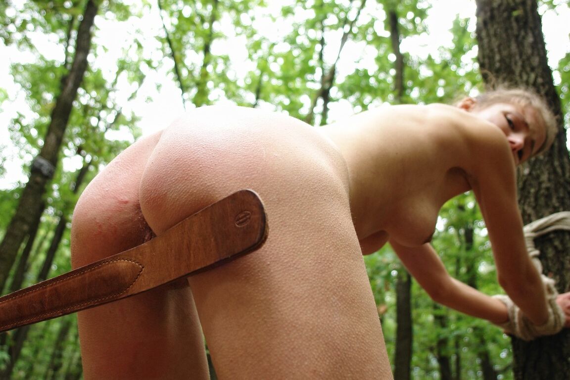 15P Petite blonde girl is flogged while tied to a tree in the forest