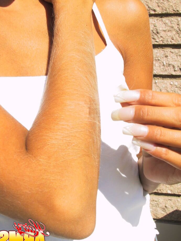 14P Le mannequin amateur Lori Anderson tire sur les poils de ses bras avec des ongles manucurés.