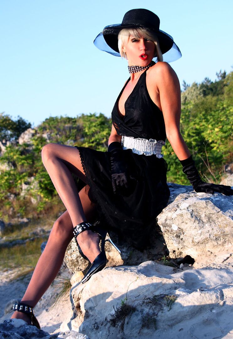 16P Classy woman Eva Diangelo releases her feet from heels and hose on a boulder