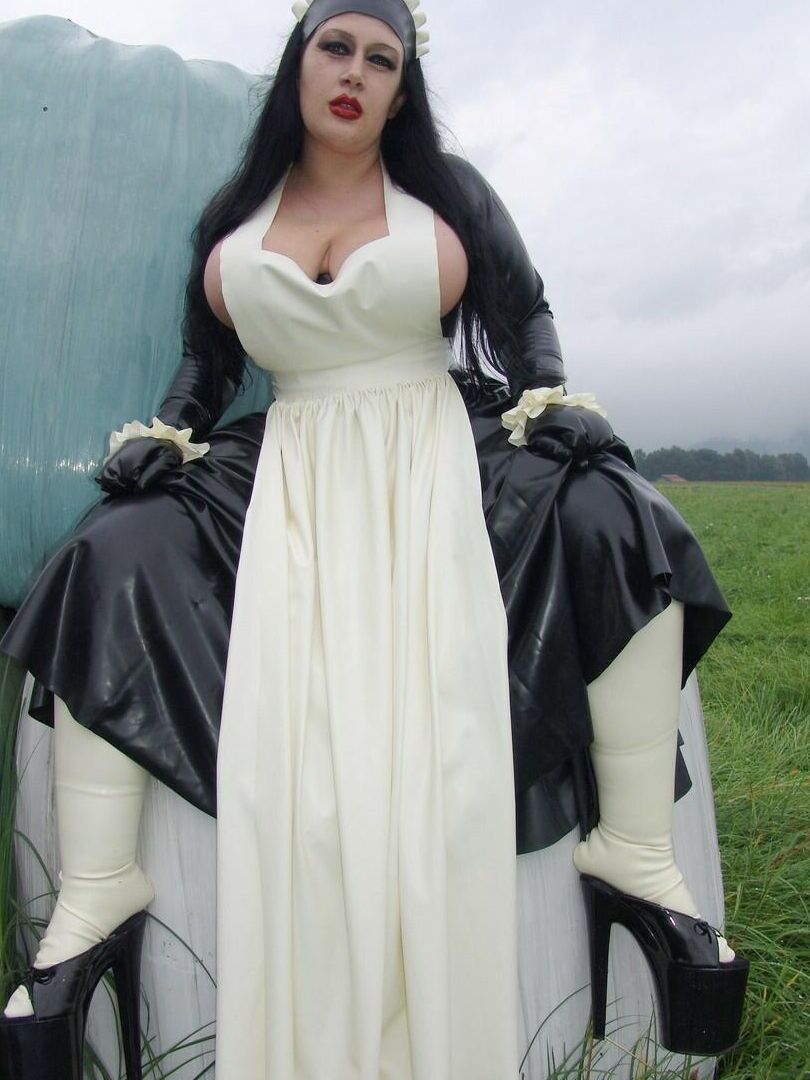 16P La mujer gótica Lady Angelina lava la ropa al aire libre en una tina con ropa de látex