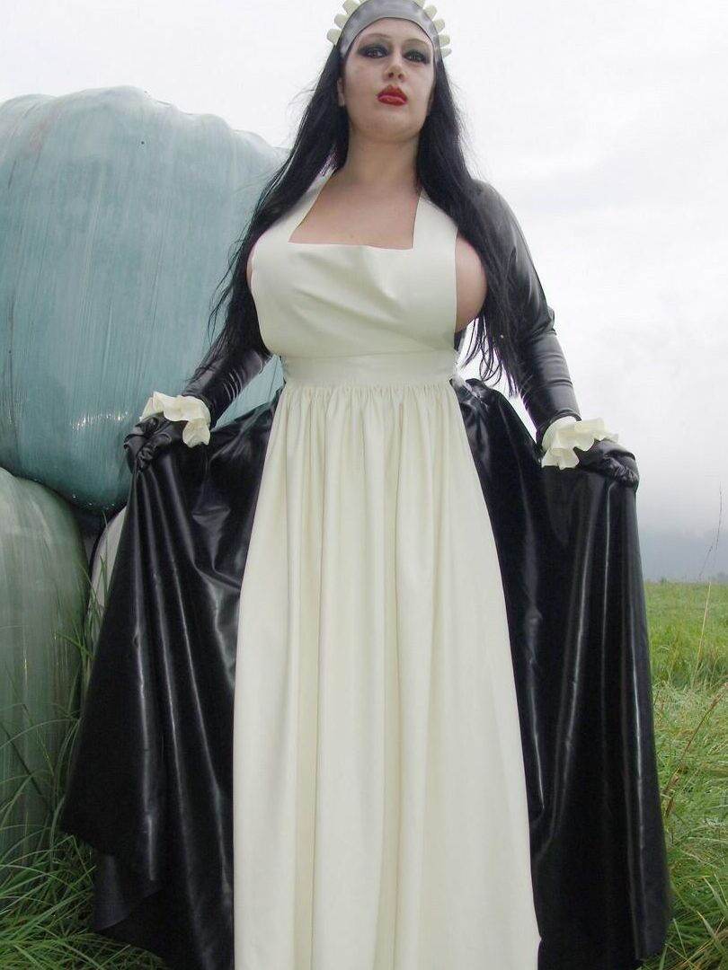 16P La mujer gótica Lady Angelina lava la ropa al aire libre en una tina con ropa de látex