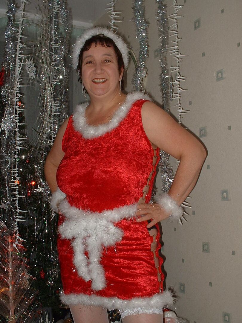 16P Mature redhead Kinky Carol uncovers her large breasts in front of an Xmas tree