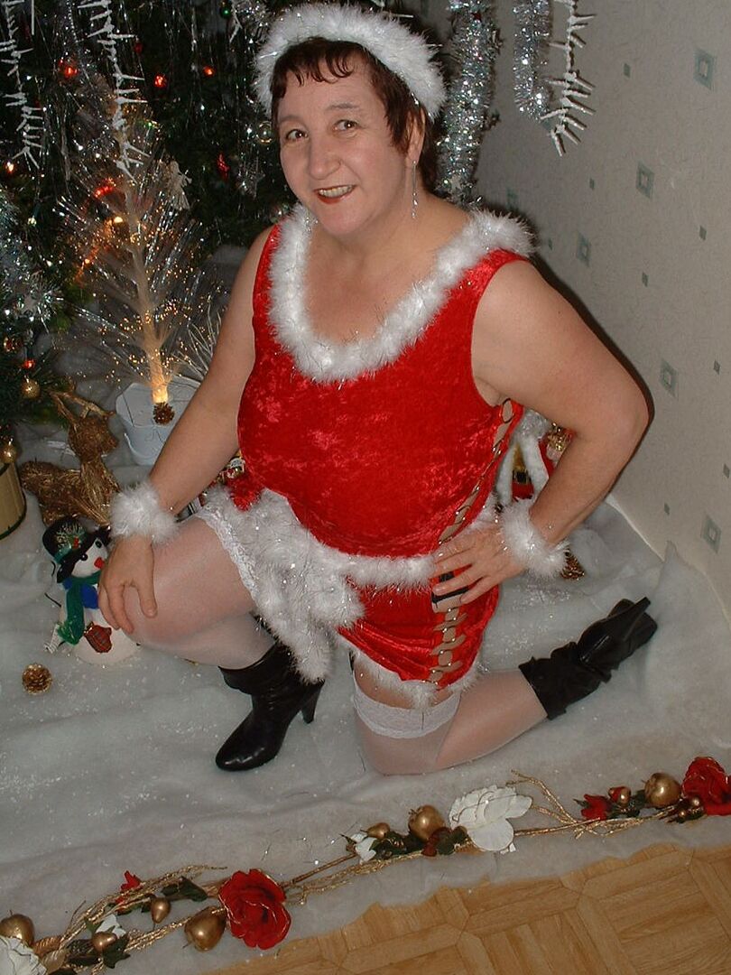 16P Mature redhead Kinky Carol uncovers her large breasts in front of an Xmas tree