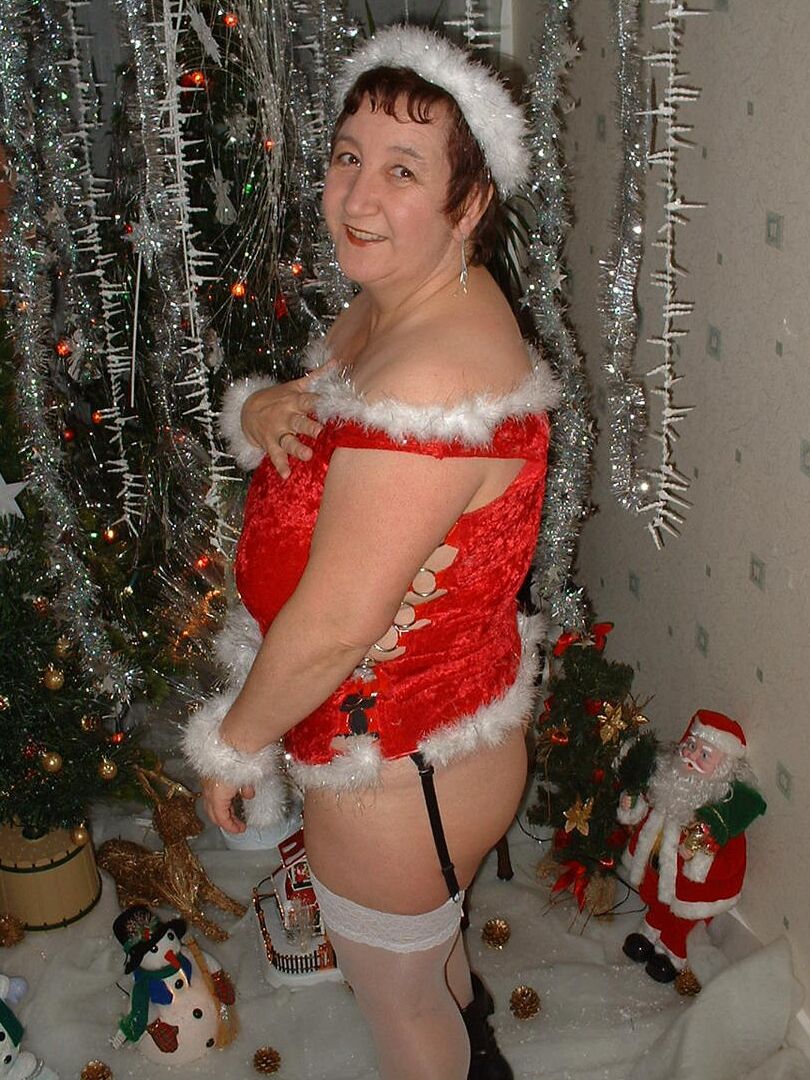 16P Mature redhead Kinky Carol uncovers her large breasts in front of an Xmas tree