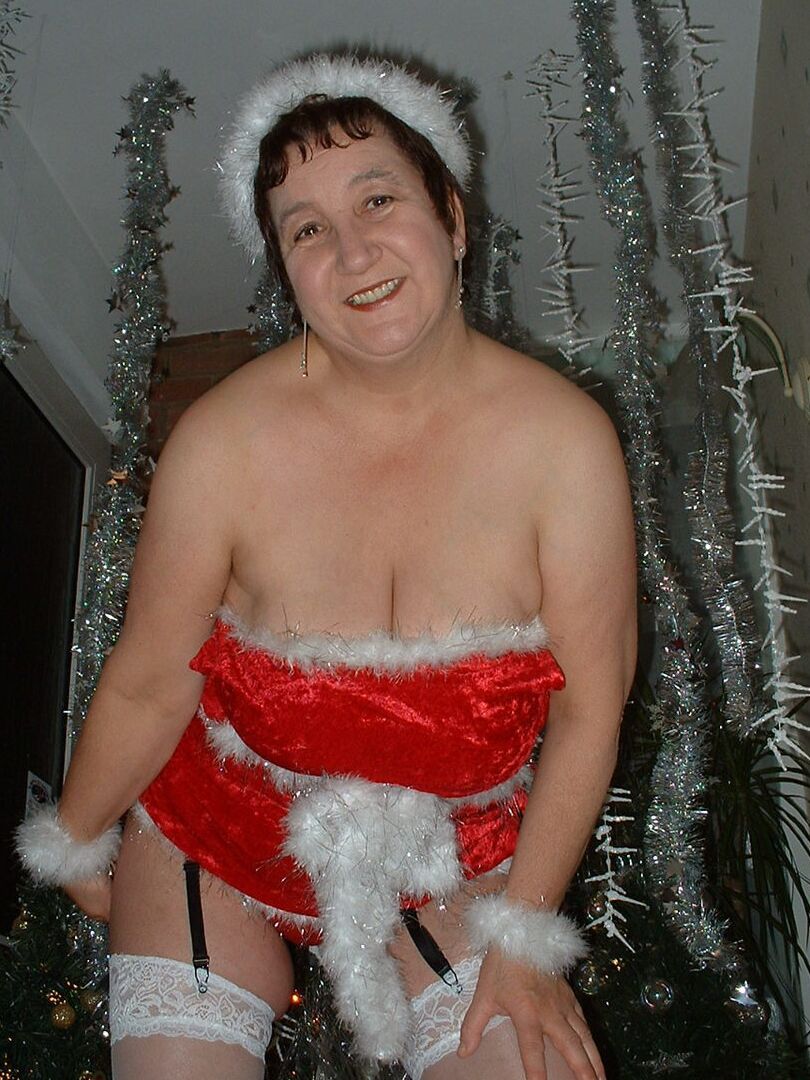 16P Mature redhead Kinky Carol uncovers her large breasts in front of an Xmas tree