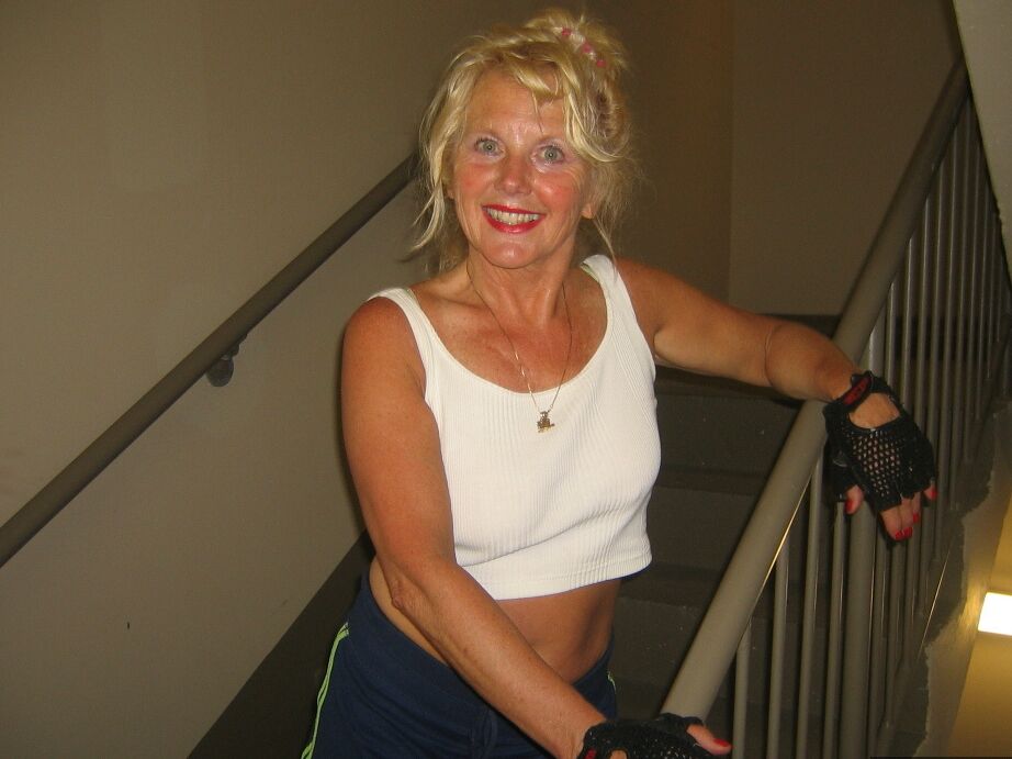 20P Mature blonde Ruth uncovers her breasts while working out at a gym