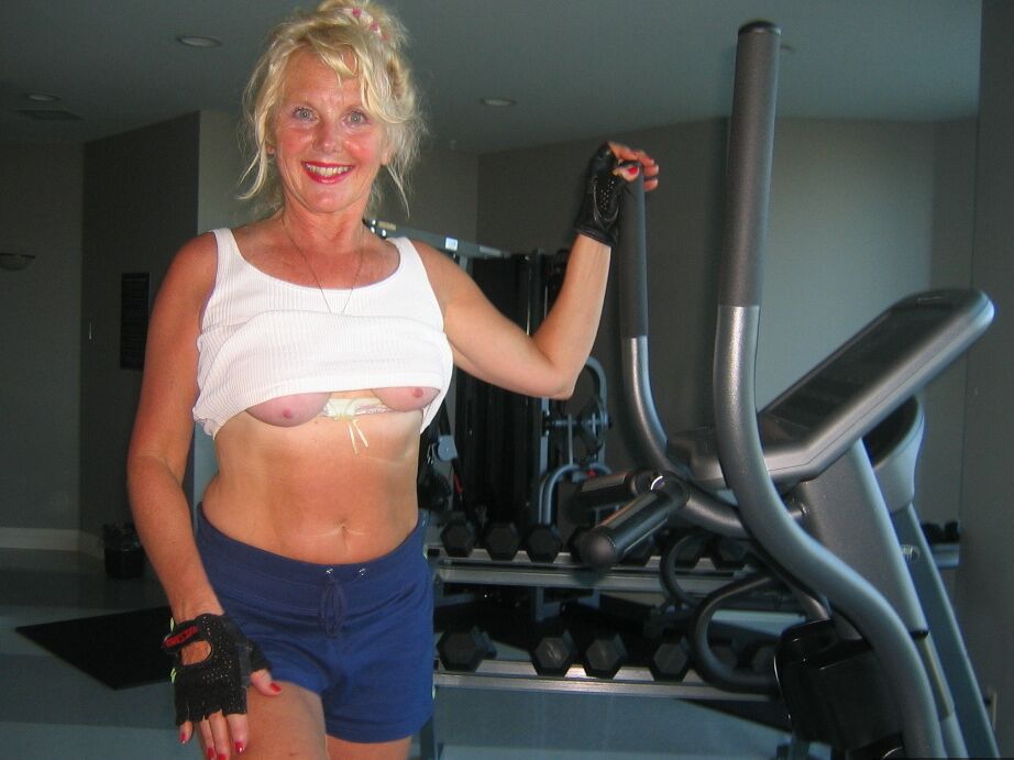 20P Mature blonde Ruth uncovers her breasts while working out at a gym
