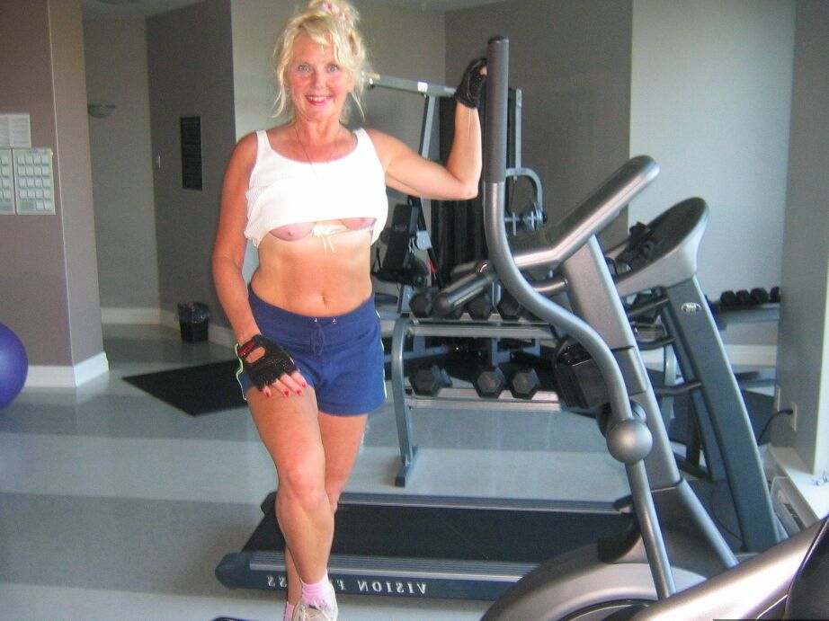 20P Mature blonde Ruth uncovers her breasts while working out at a gym