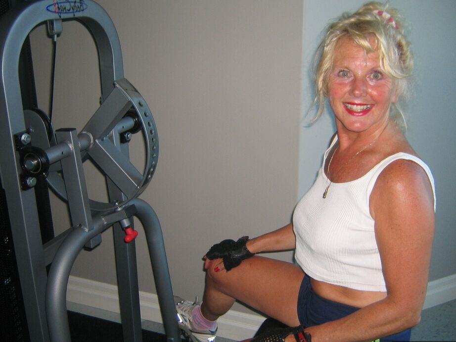 20P Mature blonde Ruth uncovers her breasts while working out at a gym