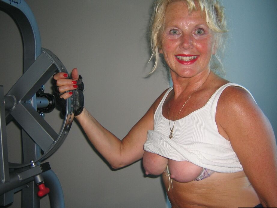 20P Mature blonde Ruth uncovers her breasts while working out at a gym
