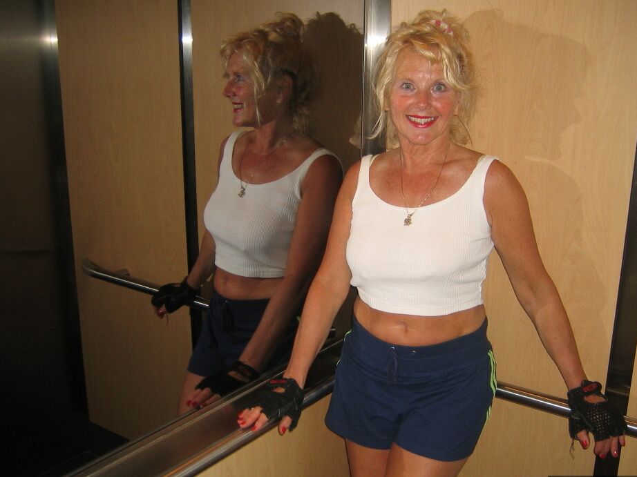20P Mature blonde Ruth uncovers her breasts while working out at a gym
