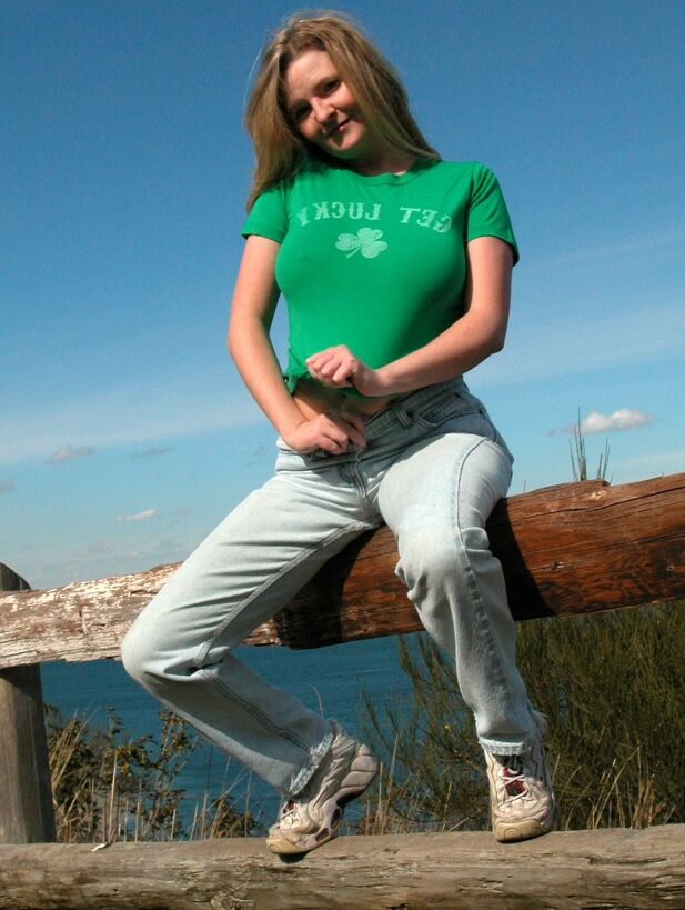 15P Mulher madura desliza jeans e calcinha pela bunda perto de uma cerca de madeira