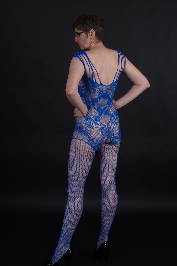 20P Un mannequin plus âgé pose dans un body sans entrejambe et des talons avec ses lunettes