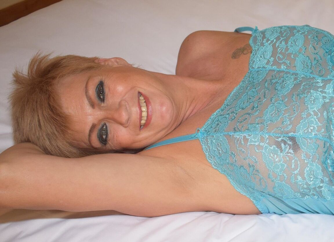 16P A loira madura Dimonty acaricia sua boceta na cama enquanto mostra seus seios naturais