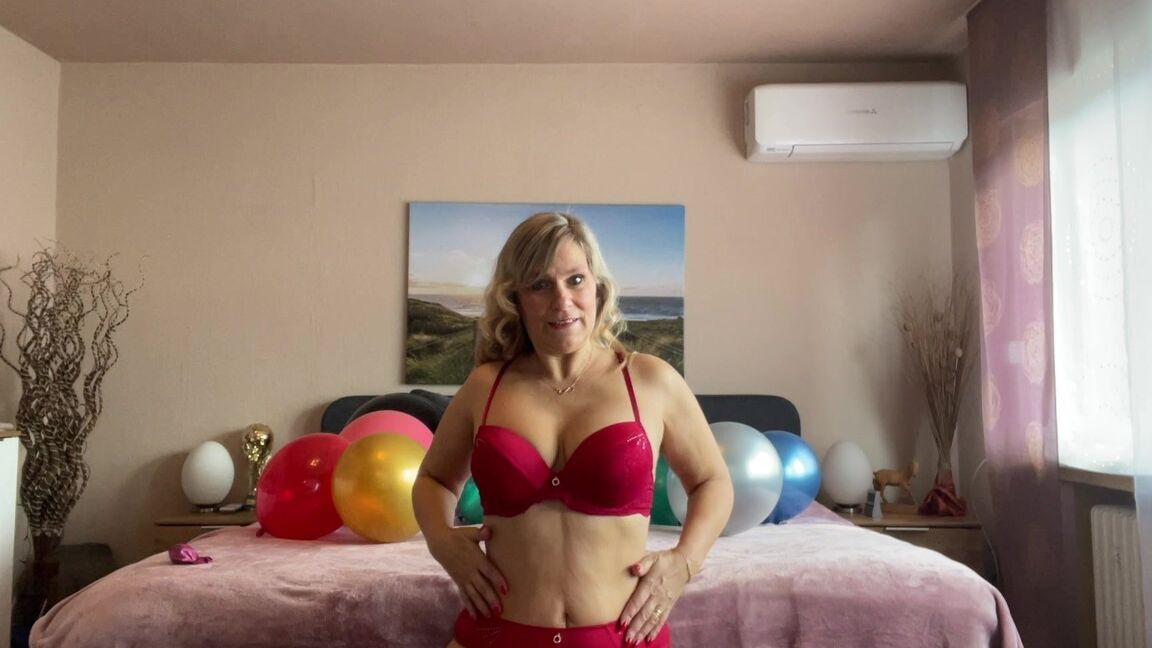 16P Middle-aged blonde Sweet Susi plays with balloons while getting naked on a bed