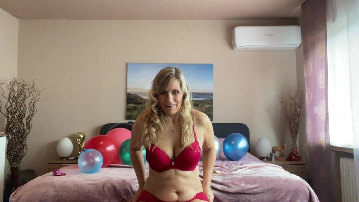 16P Middle-aged blonde Sweet Susi plays with balloons while getting naked on a bed