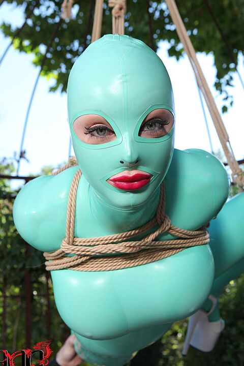 16P modelo fetichista BDSM Latex Lucy suspendida por cuerdas en traje de látex al aire libre