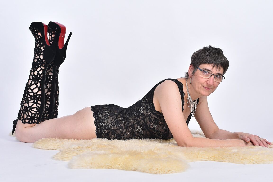 16P Mulher mais velha de cabelo curto expõe a bunda nua em um tapete de pele de urso