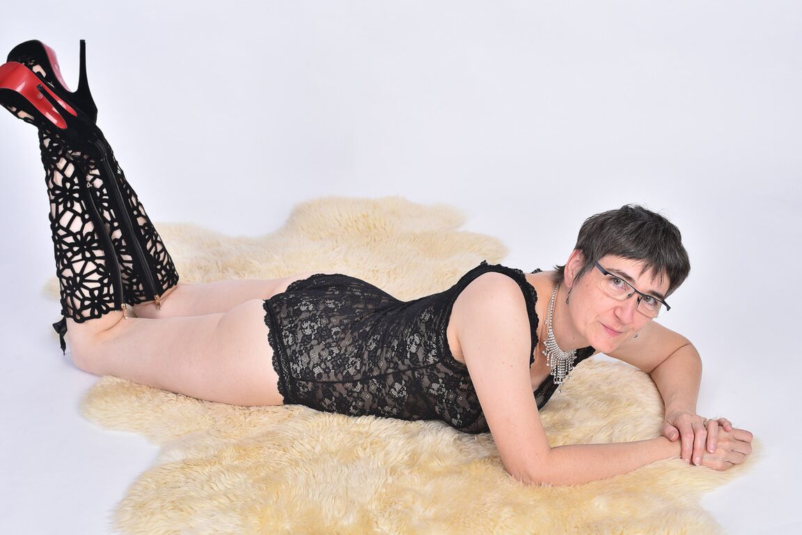 16P Mulher mais velha de cabelo curto expõe a bunda nua em um tapete de pele de urso