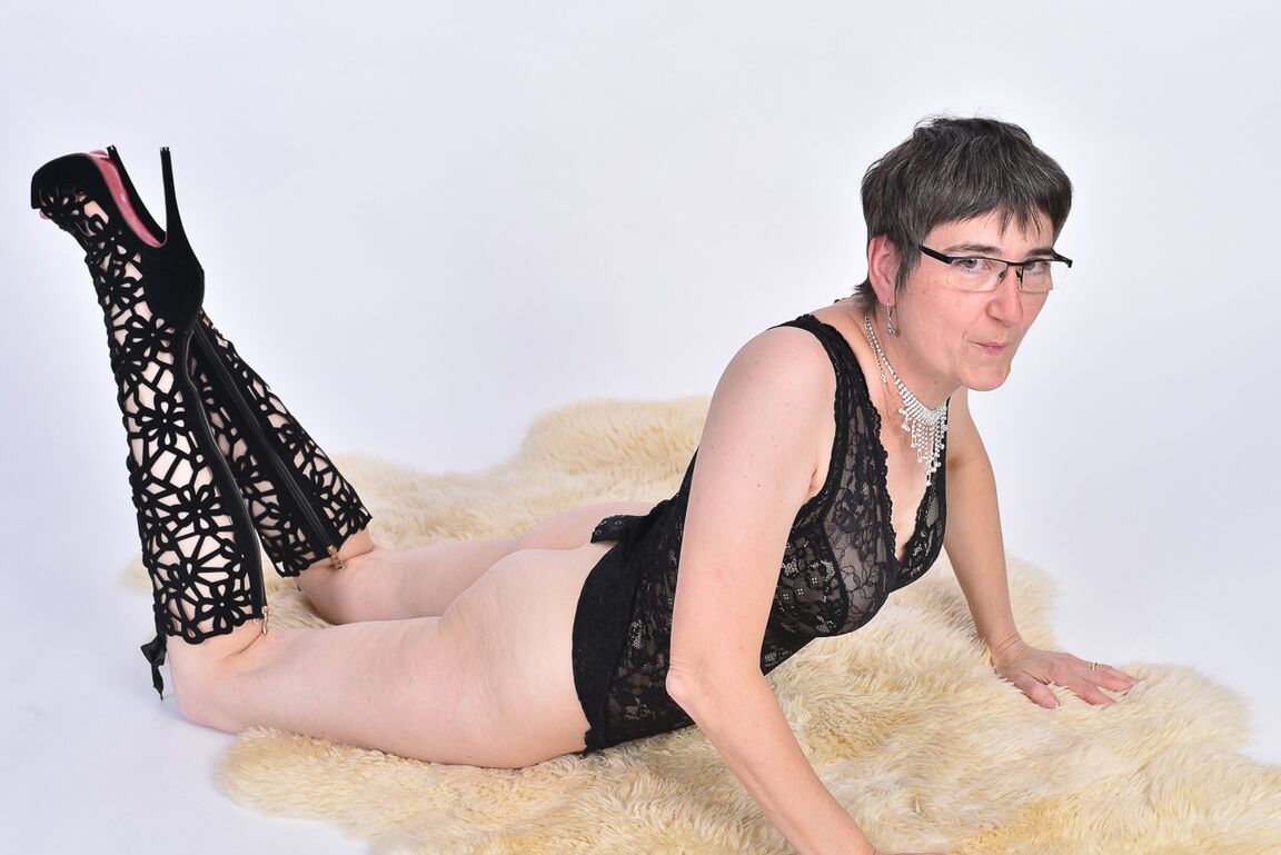 16P Mulher mais velha de cabelo curto expõe a bunda nua em um tapete de pele de urso