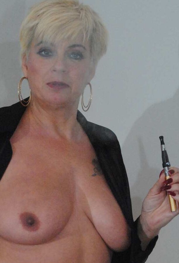 17P A amadora loira mais velha Dimonty fuma um cigarro eletrônico enquanto mostra seus seios naturais