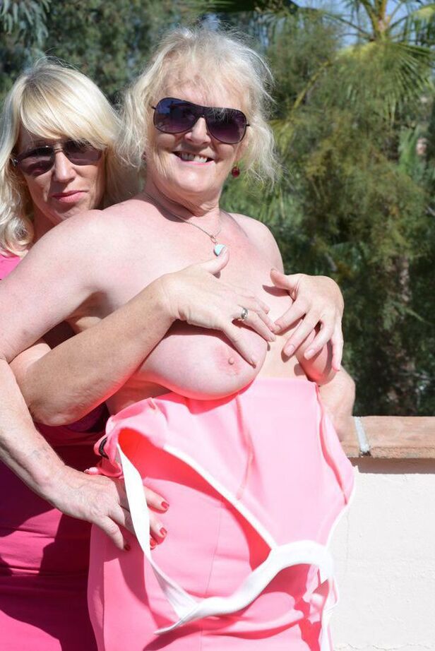 20P Melody, blonde mature, libère les seins d'une femme plus âgée d'une robe rose