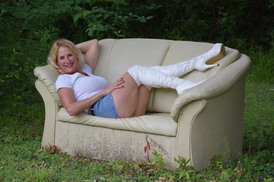 20P A modelo amadora Molly MILF mostra as coxas com botas OTK brancas e saia no quintal