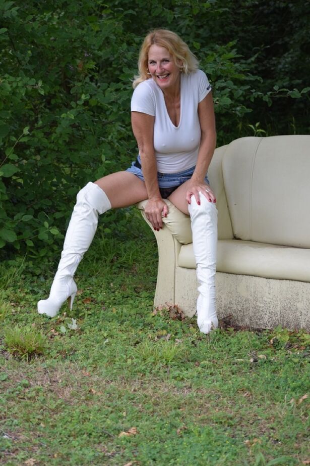 20P A modelo amadora Molly MILF mostra as coxas com botas OTK brancas e saia no quintal