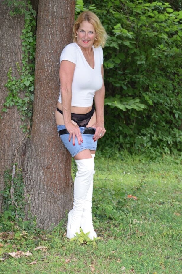 20P A modelo amadora Molly MILF mostra as coxas com botas OTK brancas e saia no quintal