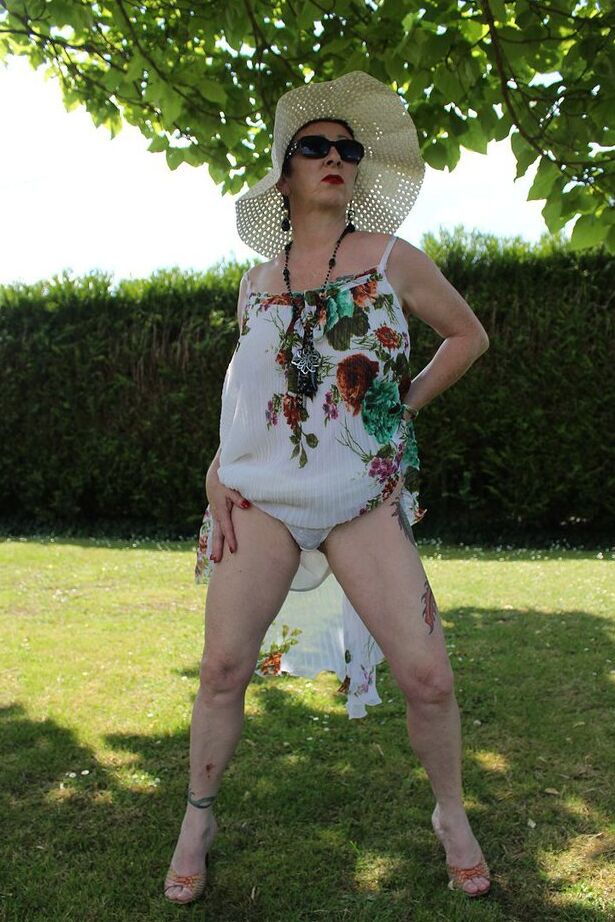 20P La madura amateur Mary Bitch se baja el tanga en el césped con un sombrero para el sol