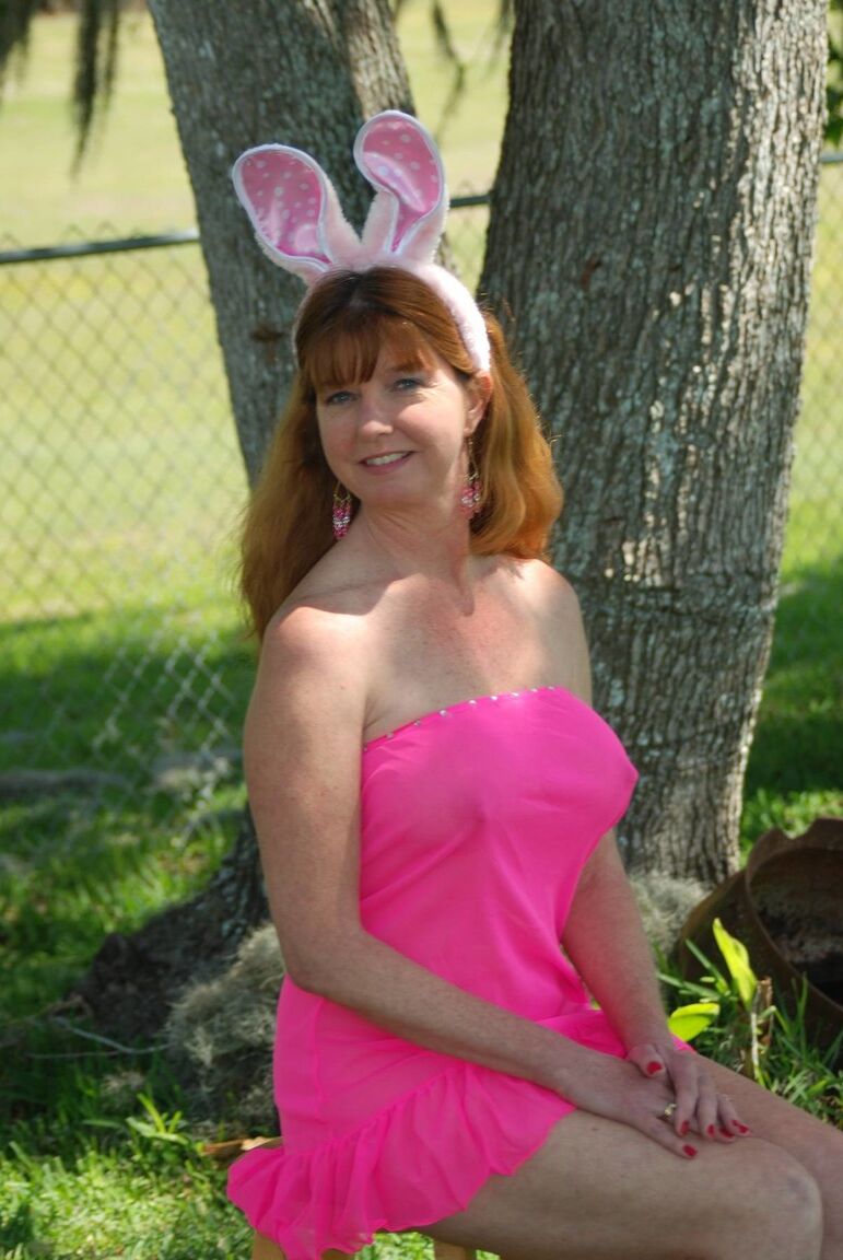 18P Older redhead Dee Delmar bares her tits and twat in yard wearing bunny ears