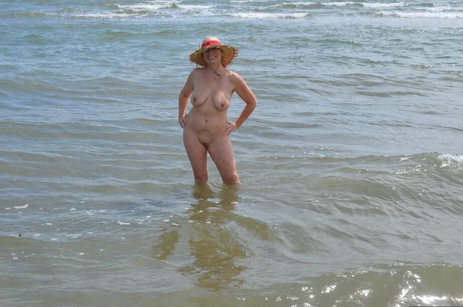 20P Older amateur Barby Slut wades into the ocean in nothing more than a sun hat