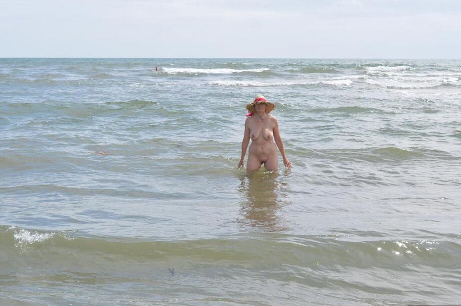 20P Older amateur Barby Slut wades into the ocean in nothing more than a sun hat