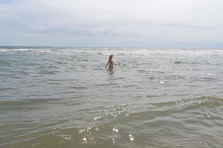 20P Older amateur Barby Slut wades into the ocean in nothing more than a sun hat