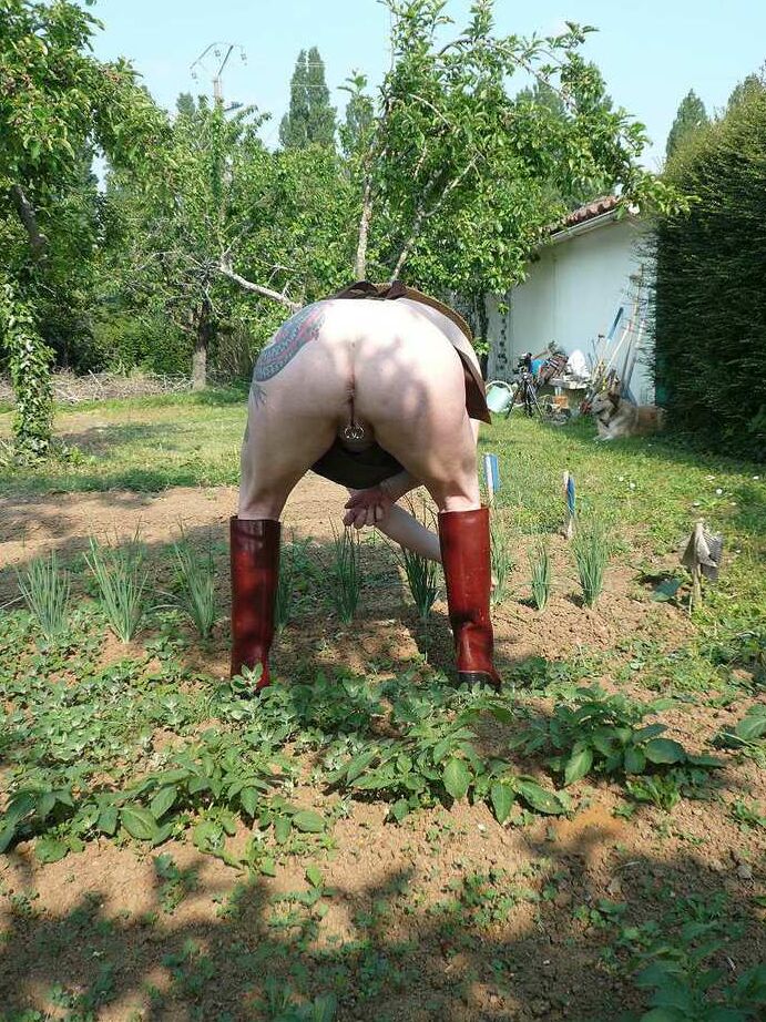 20P La señora madura Mary Bitch cuida su jardín desnuda con sombrero y delantal