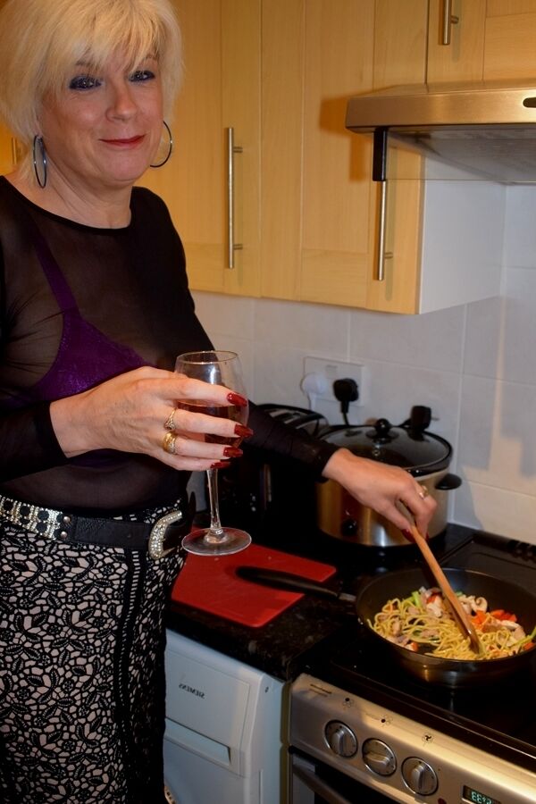 16P Mature platinum blonde prepares a stir fry while fully clothed