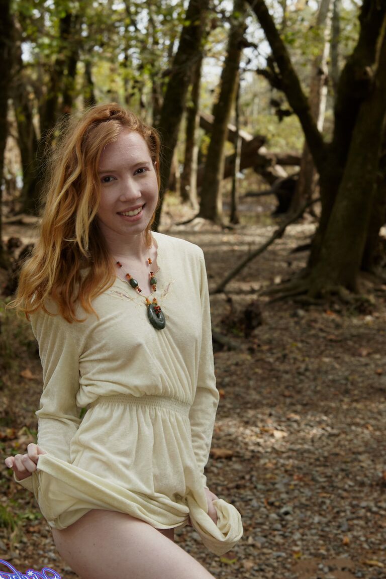 15P Natural redhead Nicki Blue shows some leg while wading into a shallow stream