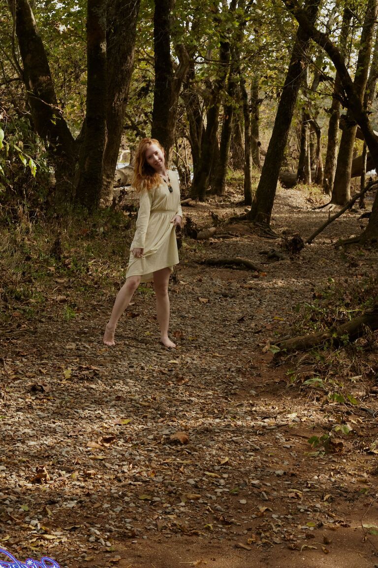 15P Natural redhead Nicki Blue shows some leg while wading into a shallow stream