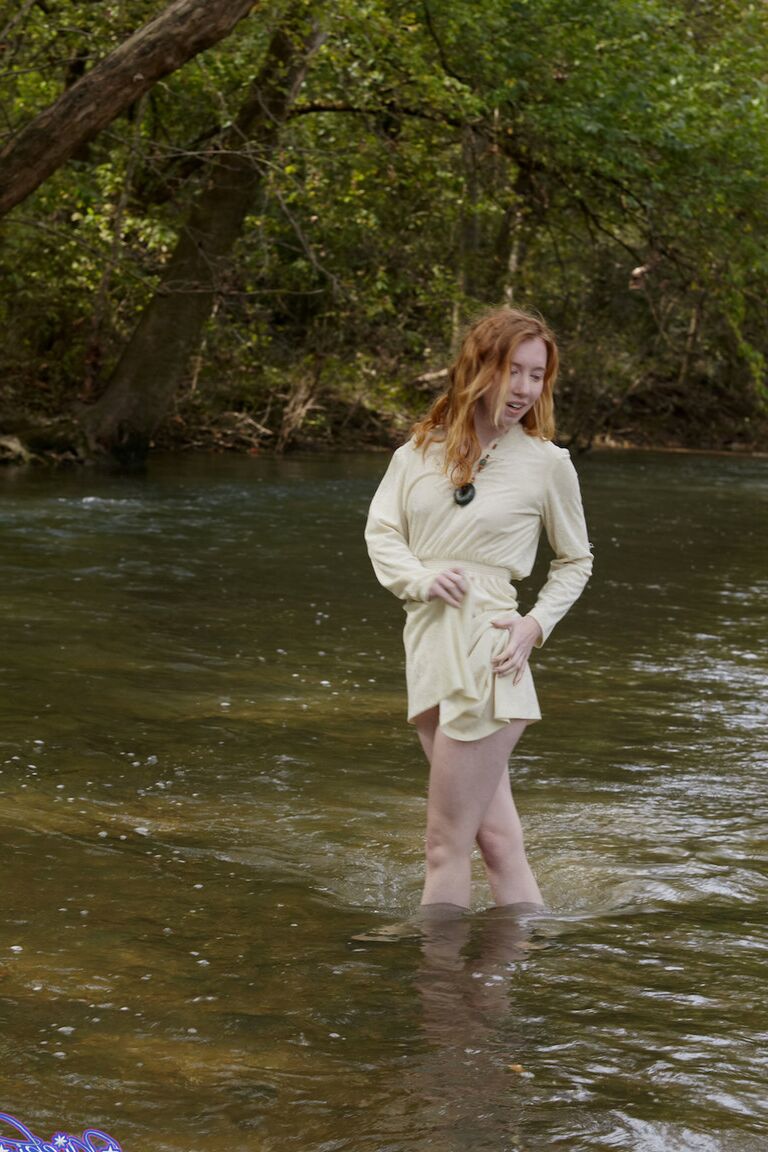 15P Natural redhead Nicki Blue shows some leg while wading into a shallow stream
