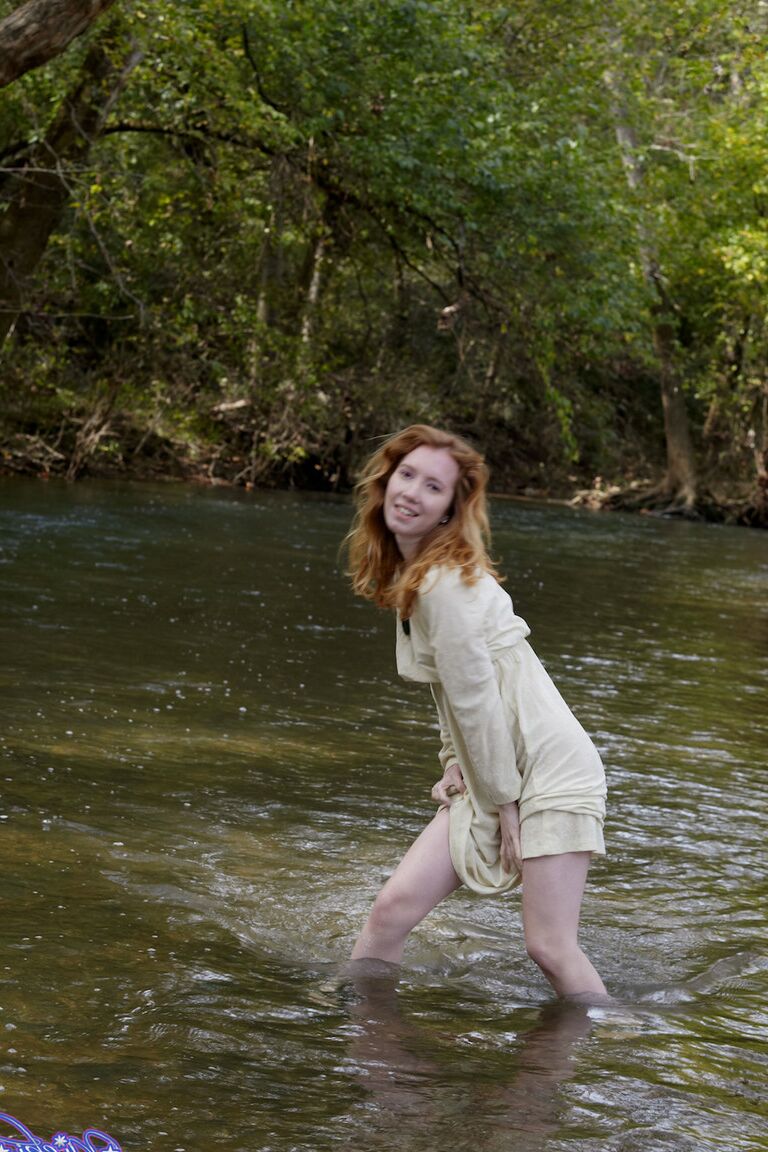 15P Natural redhead Nicki Blue shows some leg while wading into a shallow stream