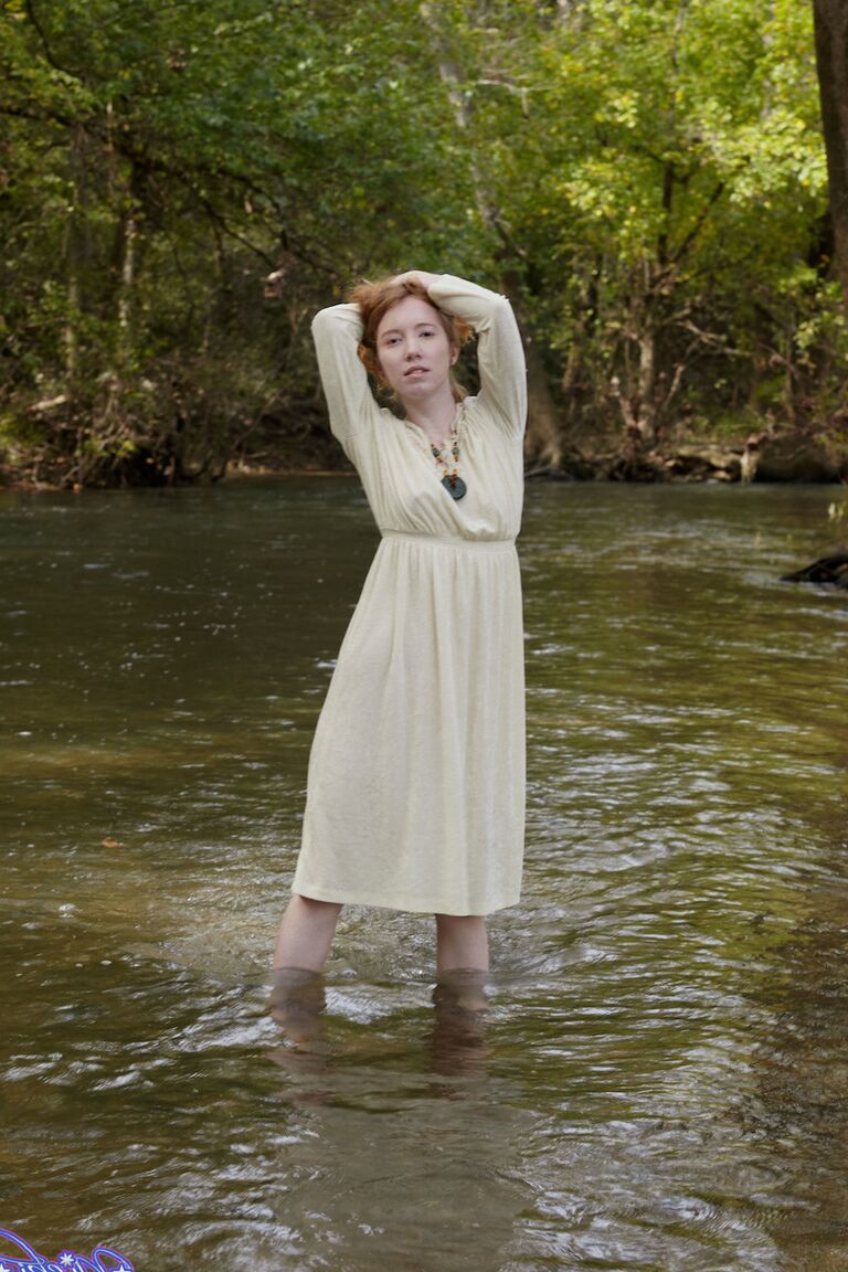 15P Natural redhead Nicki Blue shows some leg while wading into a shallow stream