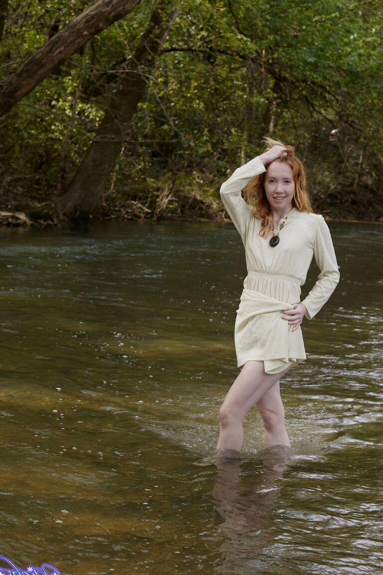15P Natural redhead Nicki Blue shows some leg while wading into a shallow stream